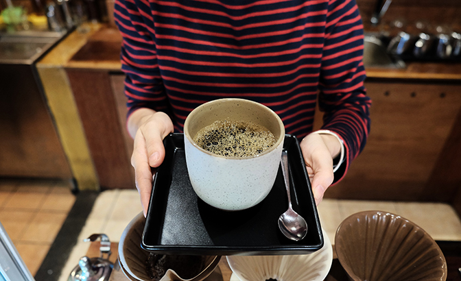 A barista serves up a large mug of coffee