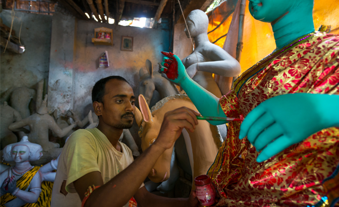An artisan applies some finishing touches to an idol