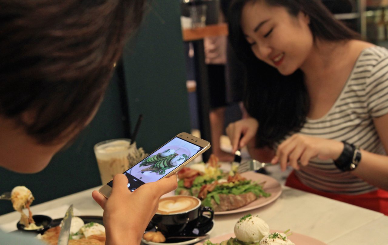 Diners taking photos of their food in Singapore