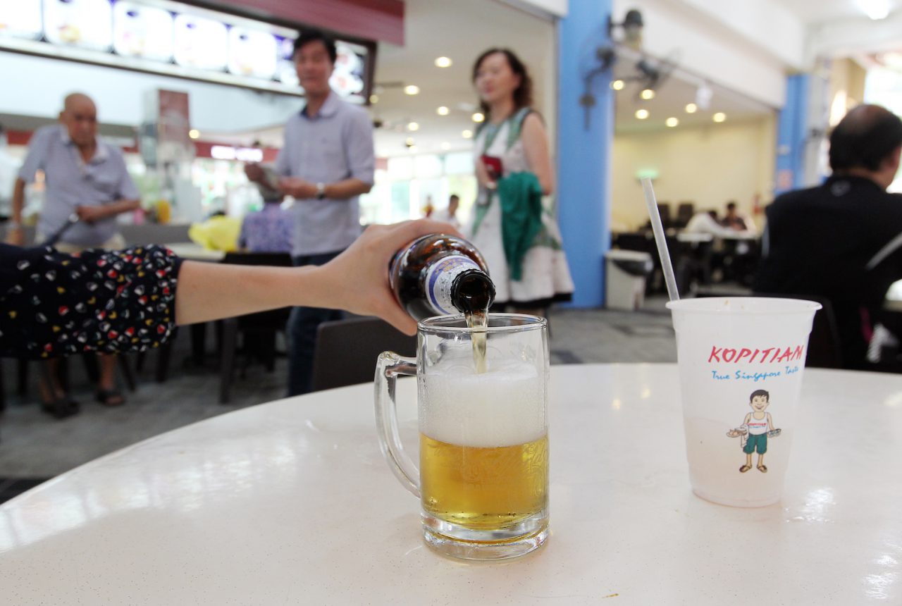 Tiger Beer being poured into a mug in a Singapore coffeeshop
