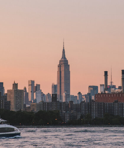 A view of the Empire State Building across the East River from Domino Park in the Williamsburg neighborhood of Brooklyn, NY.